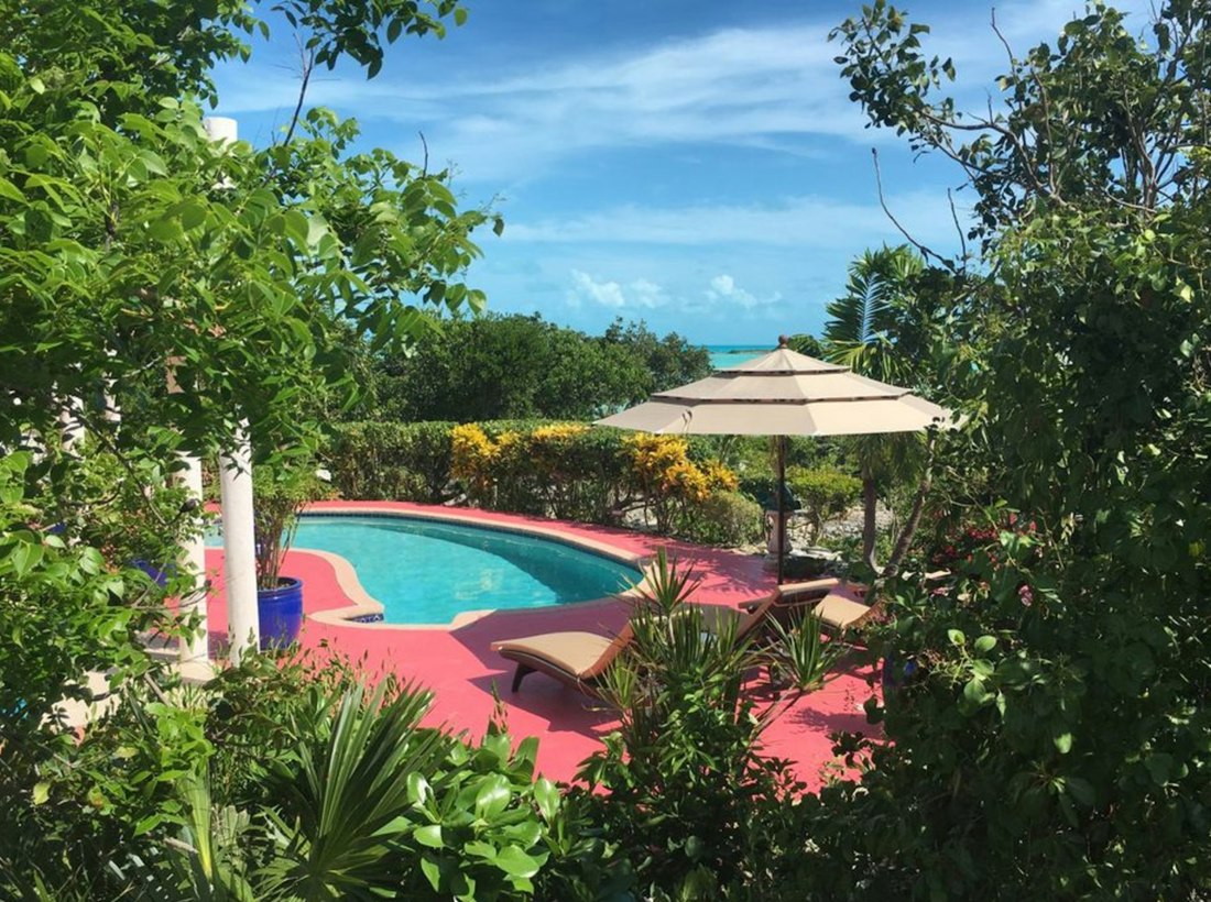 Piscina y jardín tropical con vista al mar